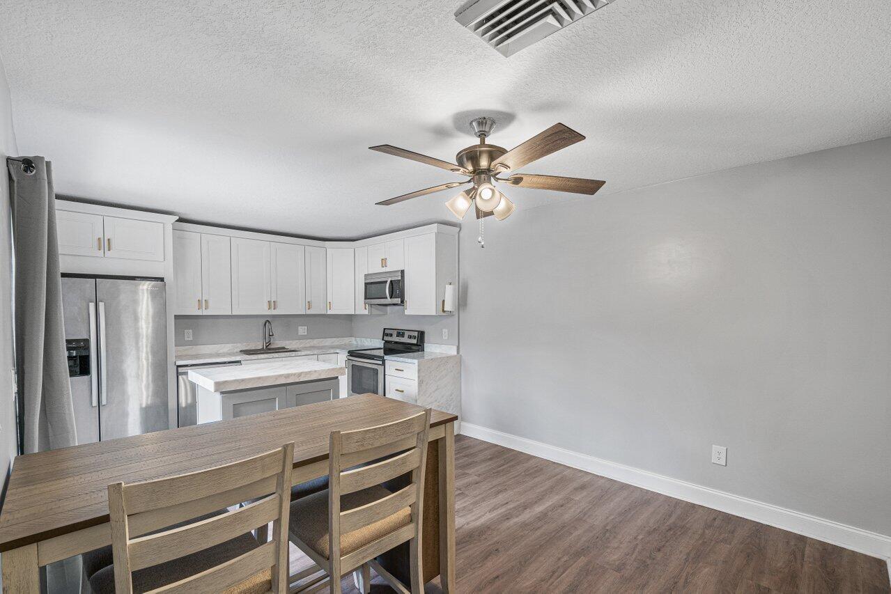 22172 Boca Rancho Drive, Unit D Boca Raton, FL 33428 - Photo 5 of 15 a kitchen with stainless steel appliances a stove a refrigerator and cabinets