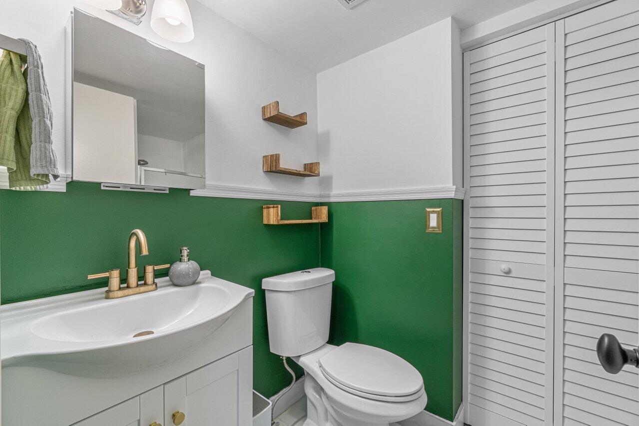 22172 Boca Rancho Drive, Unit D Boca Raton, FL 33428 - Photo 8 of 15 a bathroom with a sink a toilet and mirror