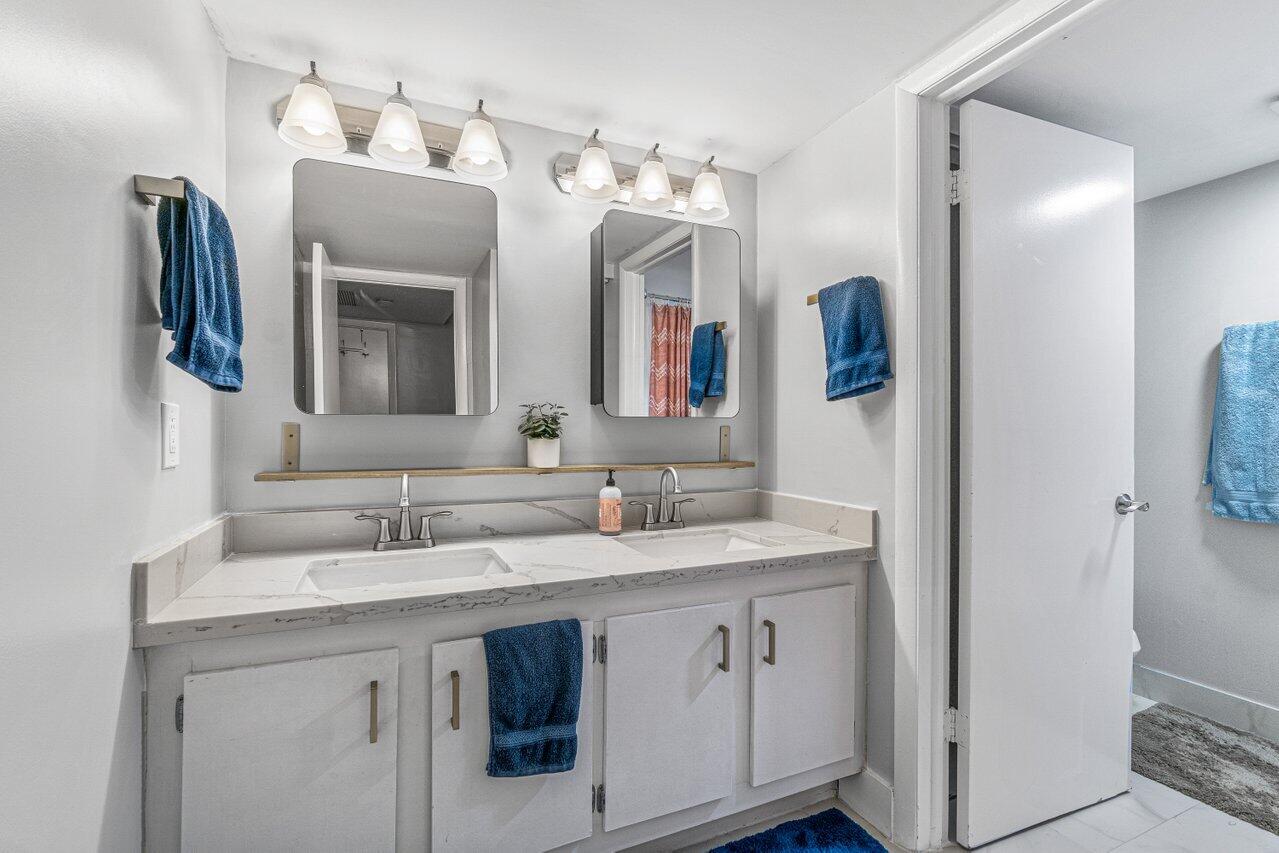 22172 Boca Rancho Drive, Unit D Boca Raton, FL 33428 - Photo 10 of 15 a bathroom with a double vanity sink and mirror