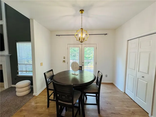 a dining room with furniture a chandelier and wooden floor