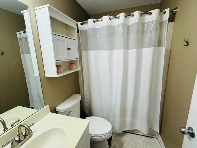 a white toilet sitting next to a bathroom sink