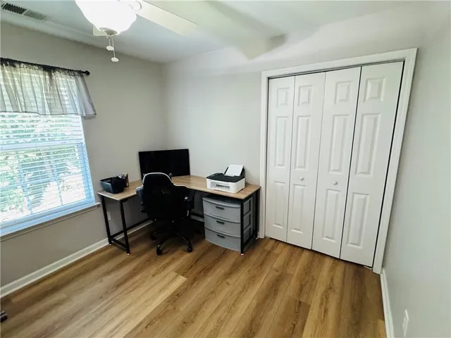a view of a workspace with furniture and a window