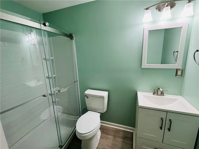 a bathroom with a toilet sink vanity and mirror