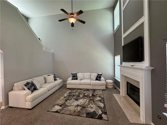 a living room with furniture a fireplace and a flat screen tv