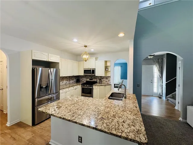 a large kitchen with kitchen island a sink stove and refrigerator