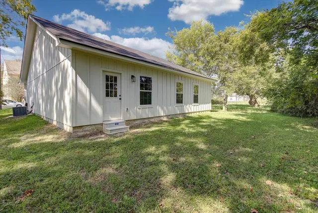 a backyard of a house with table and chairs