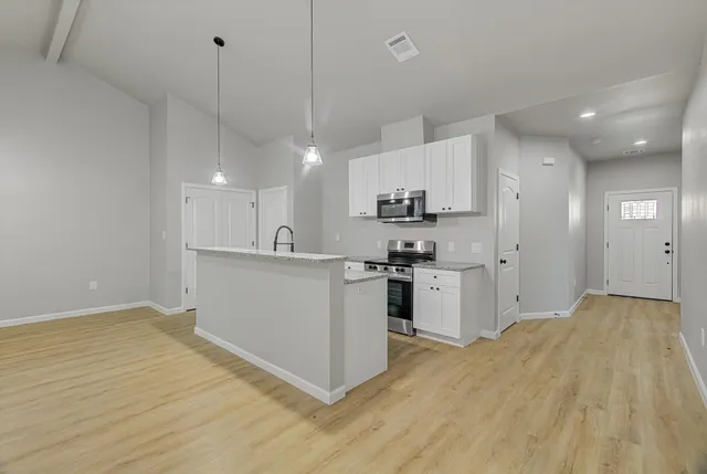 a kitchen with white cabinets and stainless steel appliances