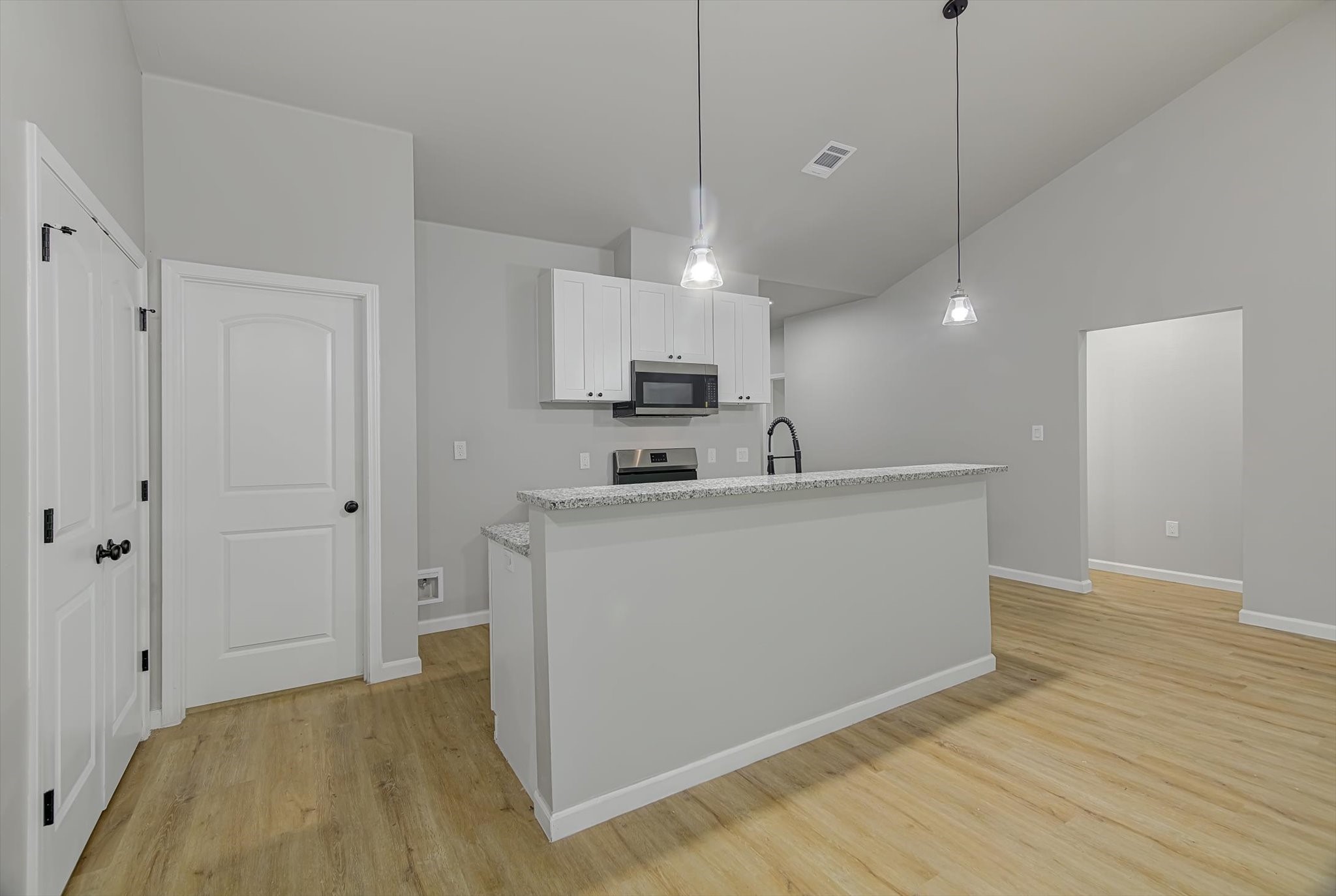 2355 Pecan Street Beaumont, TX 77701 - Photo 9 of 34 a living room with stainless steel appliances kitchen island a sink wooden floor and entryway view