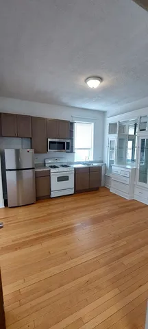 a large kitchen with stainless steel appliances a large window in it