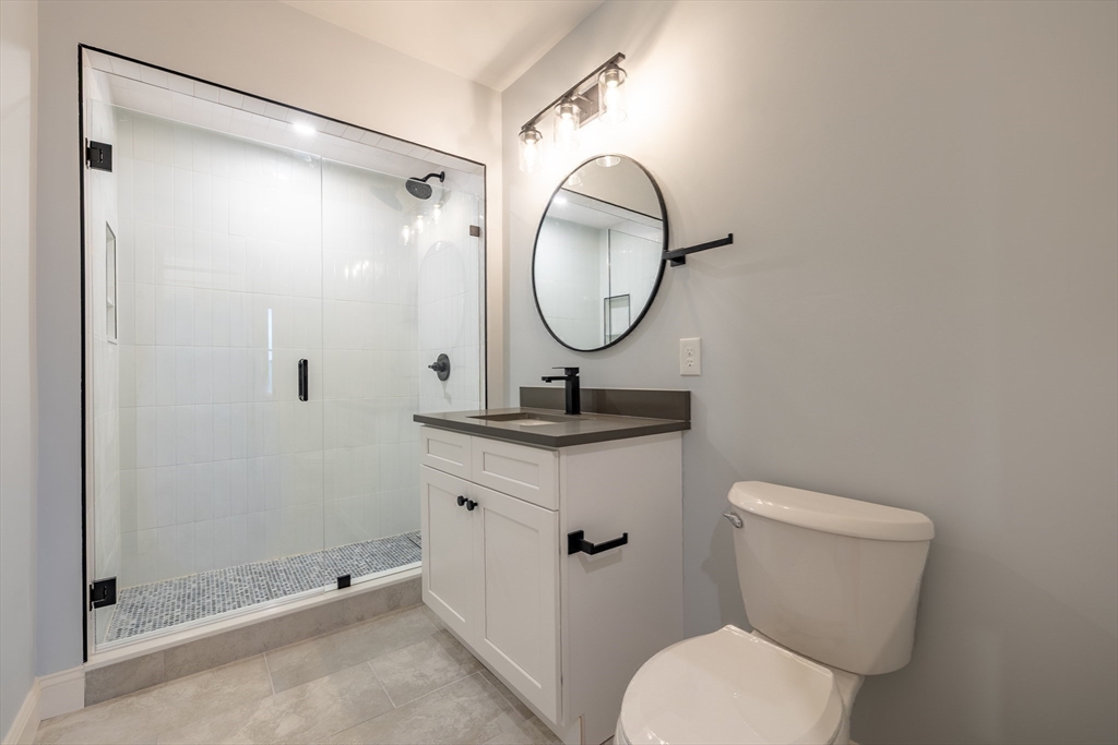 663 Columbia Road, Unit 1 Boston, MA 02125 - Photo 7 of 12 a bathroom with a toilet a sink and a mirror