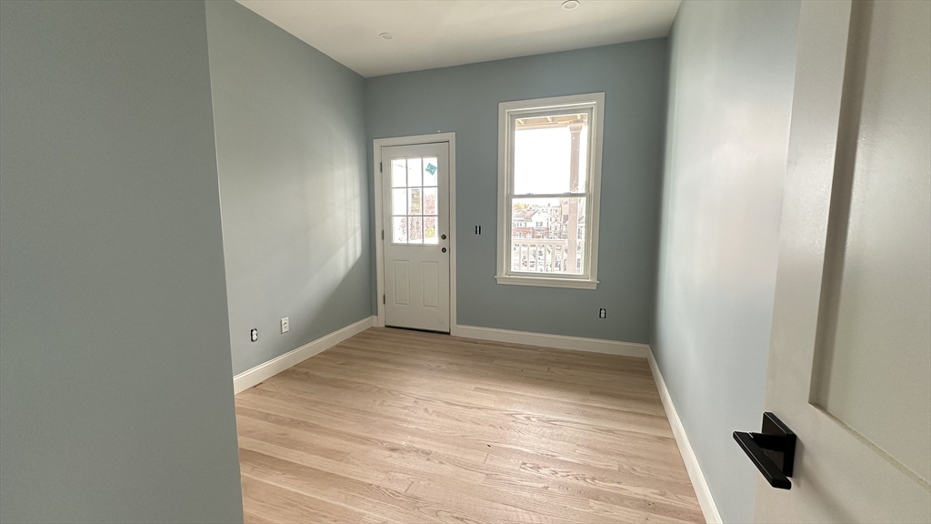 663 Columbia Road, Unit 1 Boston, MA 02125 - Photo 9 of 12 an empty room with windows and closet