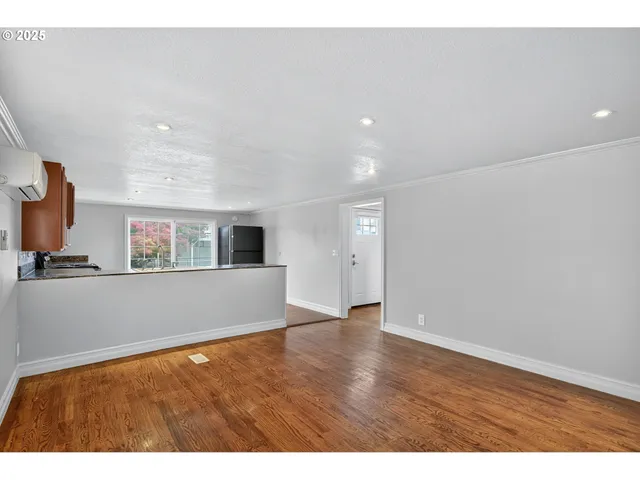 a view of empty room with wooden floor
