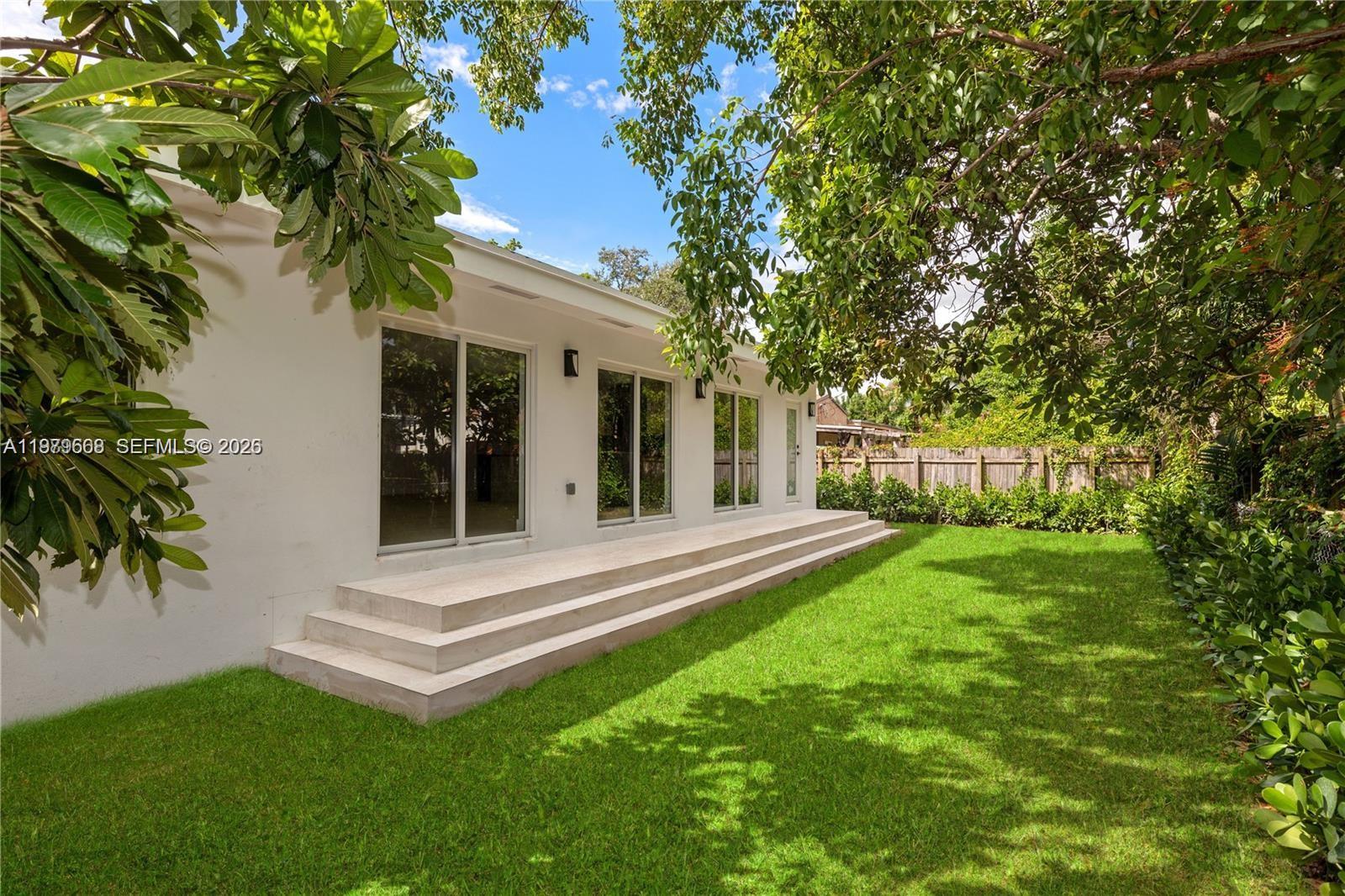 2251 Southwest 20th Street Miami, FL 33145 - Photo 30 of 36 a view of a white house with a big yard and large trees