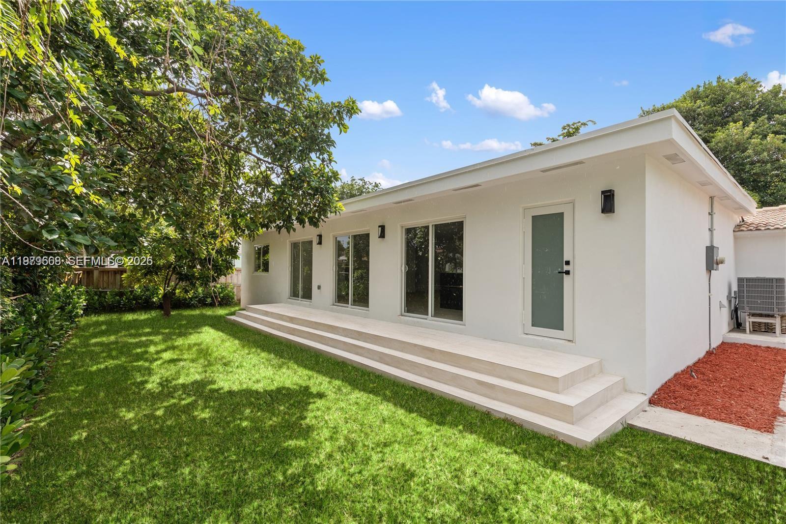 2251 Southwest 20th Street Miami, FL 33145 - Photo 34 of 36 a view of a white house in front of a yard with potted plants