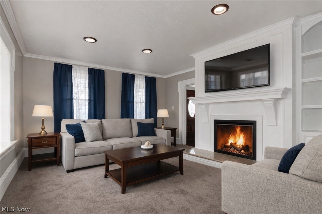 30200 Ridge Road Wickliffe, OH 44092 - Photo 16 of 43 Living room with ornamental molding, carpet floors, and a lit fireplace