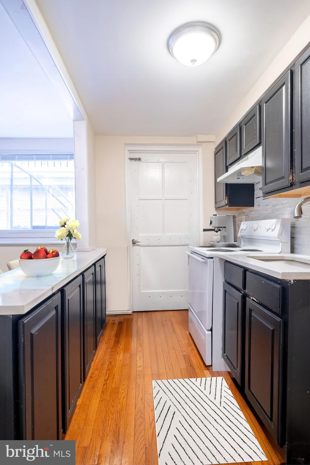 1736 Pine Street, Unit 3R Philadelphia, PA 19103 - Photo 5 of 14 a kitchen with stainless steel appliances granite countertop a sink stove microwave and cabinets