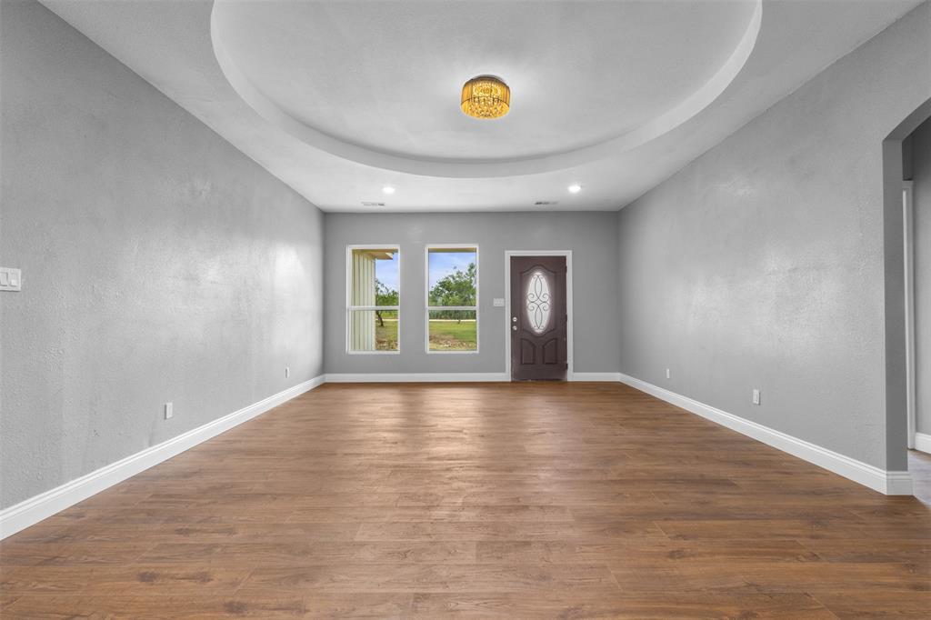 7074 Northeast County Road Rice, TX 75155 - Photo 2 of 22 wooden floor in an empty room with a window