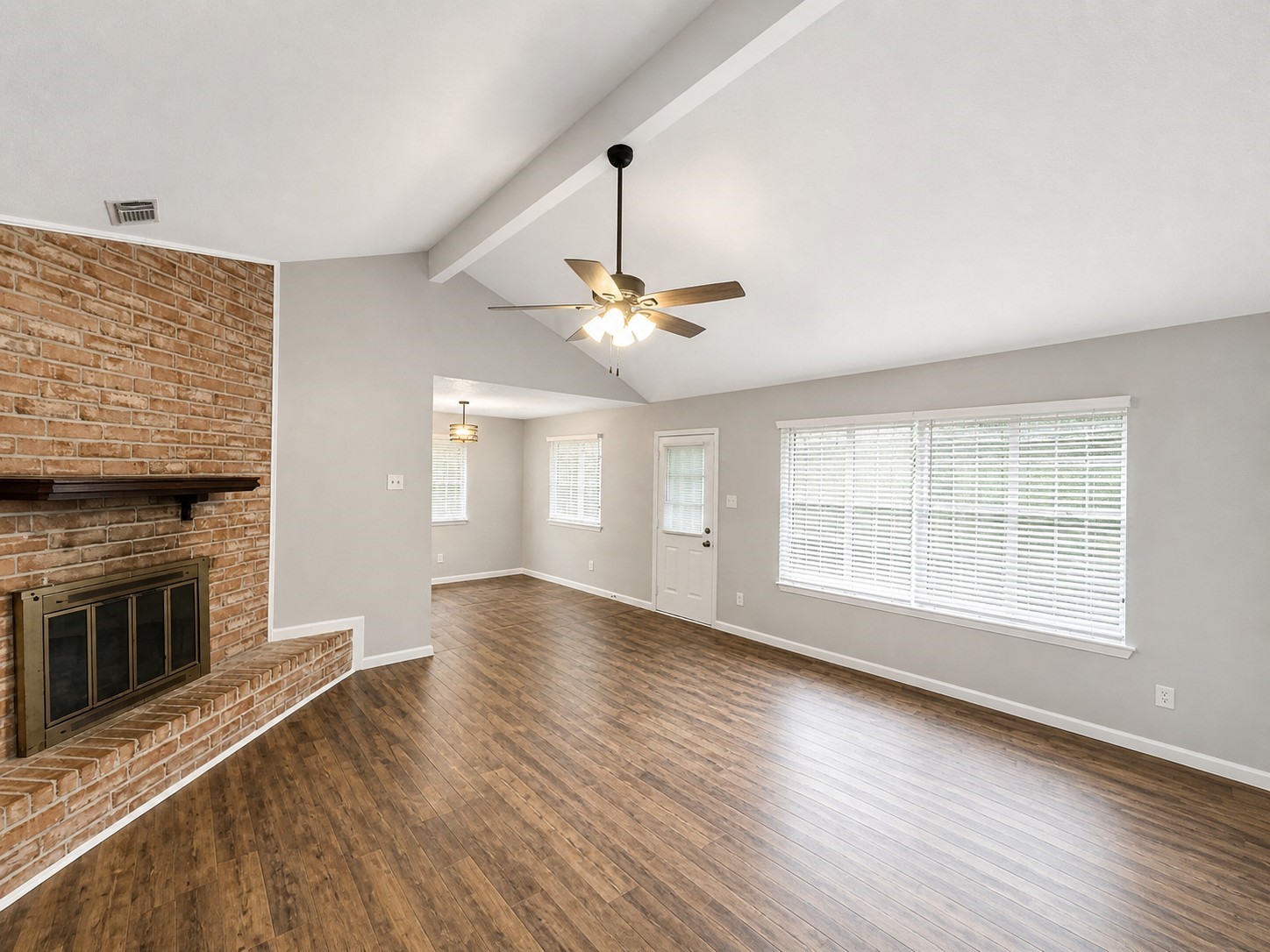 15950 Chimney Rock Road Missouri City, TX 77489 - Photo 3 of 9 an empty room with wooden floor fan and windows