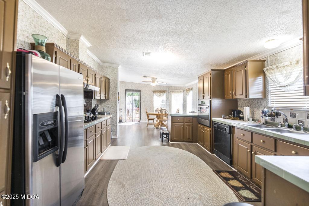 100 Coventry Manor Court Byron, GA 31008 - Photo 12 of 29 a kitchen with stainless steel appliances kitchen island granite countertop a refrigerator a sink a stove and white cabinets with wooden floor