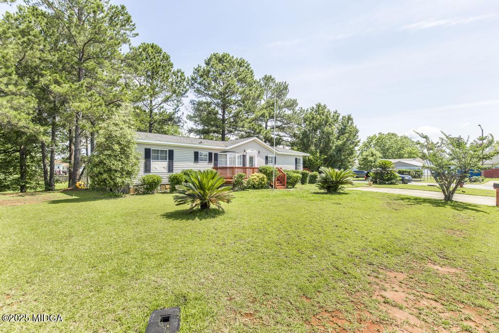 100 Coventry Manor Court Byron, GA 31008 - Photo 2 of 29 a yellow house with swimming pool in front of it