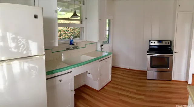 a kitchen with wooden floors and stainless steel appliances