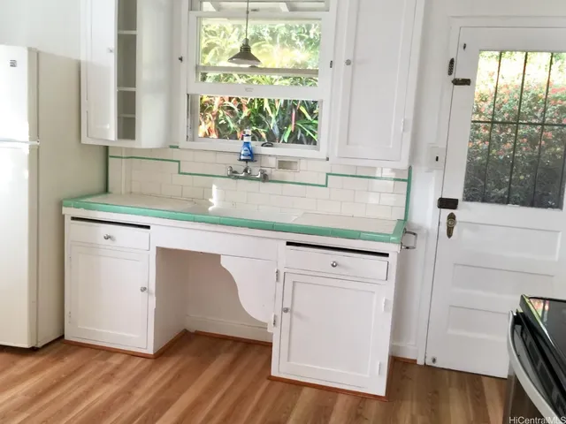 a kitchen with appliances cabinets and a large window
