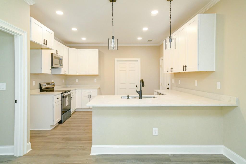 5342 Monarch Drive Gainesville, GA 30506 - Photo 9 of 27 a kitchen with kitchen island white cabinets and stainless steel appliances