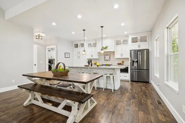 a view of a kitchen with kitchen island stainless steel appliances wooden floor and chair