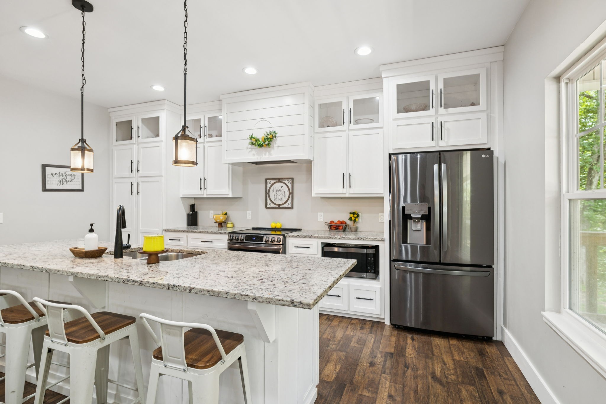 977 Elzie Williams Road Red Boiling Springs, TN 37150 - Photo 20 of 52 a kitchen with granite countertop stainless steel appliances a refrigerator a sink a stove a counter space and wooden floor