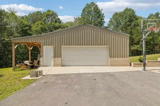 a view of a house with backyard and a parking space