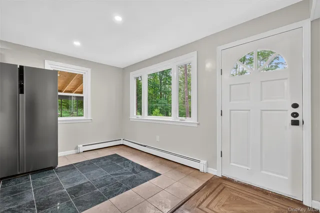 a kitchen with stainless steel appliances granite countertop a sink a stove a refrigerator and white cabinets with wooden floor