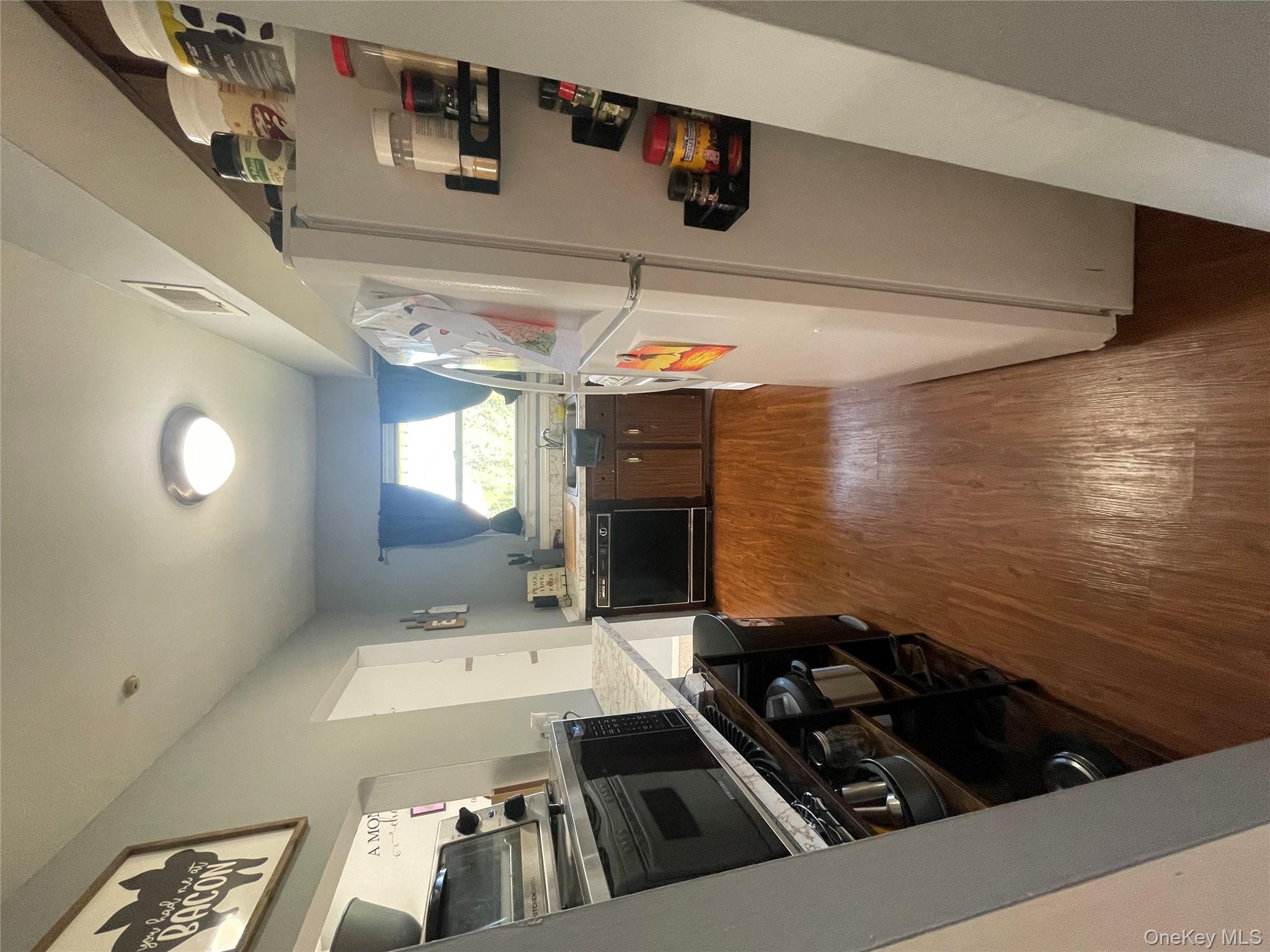 51 Rocky Point Yaphank Road, Unit 2 Rocky Point, NY 11778 - Photo 11 of 14 a kitchen with wooden floors and stainless steel appliances