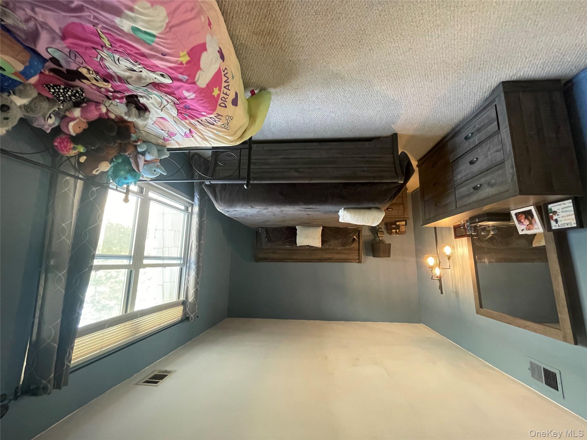 51 Rocky Point Yaphank Road, Unit 2 Rocky Point, NY 11778 - Photo 12 of 14 a bedroom with a bed window and couch