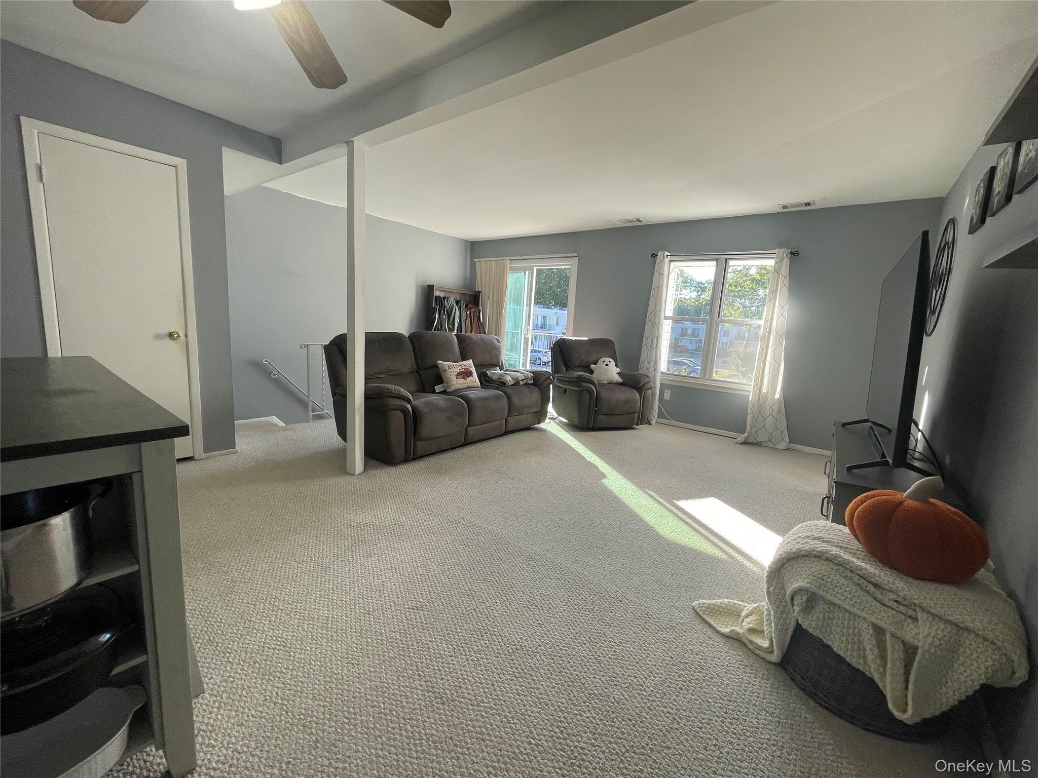 51 Rocky Point Yaphank Road, Unit 2 Rocky Point, NY 11778 - Photo 8 of 14 a living room with furniture gym equipment and a window