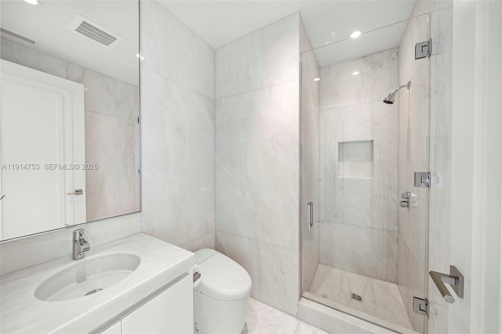 17901 Collins Avenue, Unit 4507 Sunny Isles Beach, FL 33160 - Photo 20 of 58 a bathroom with a shower sink vanity mirror and toilet