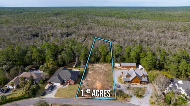 a view of a street with a yard and wooden fence