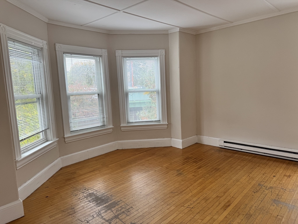 41 Pleasant Street, Unit 1 Attleboro, MA 02703 - Photo 2 of 9 an empty room with wooden floor and windows