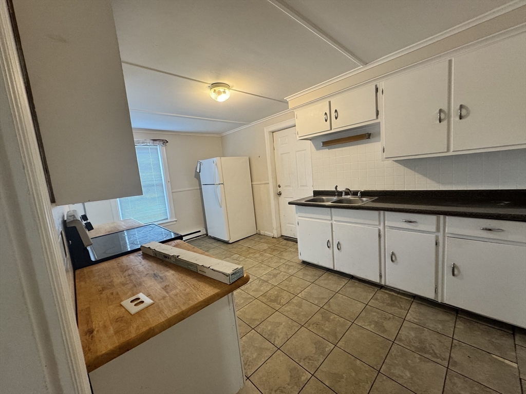 41 Pleasant Street, Unit 1 Attleboro, MA 02703 - Photo 4 of 9 a kitchen with stainless steel appliances granite countertop a sink and cabinets
