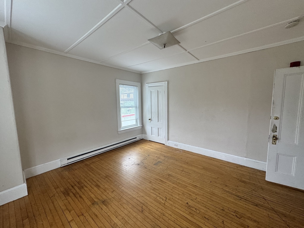41 Pleasant Street, Unit 1 Attleboro, MA 02703 - Photo 5 of 9 a view of an empty room with wooden floor and a window