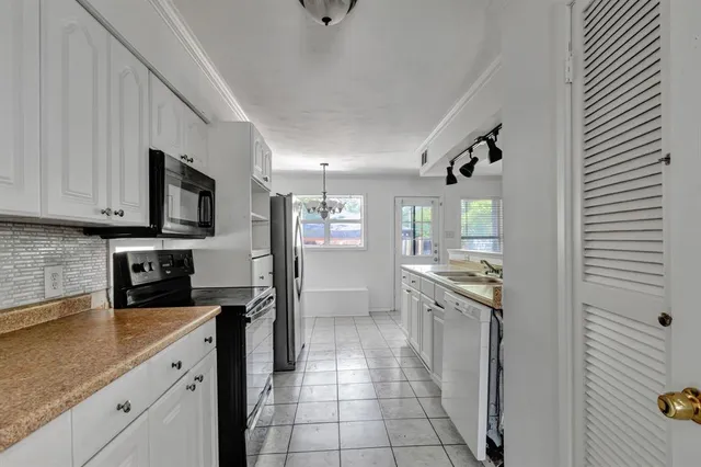 a kitchen with stainless steel appliances granite countertop a refrigerator and a stove top oven