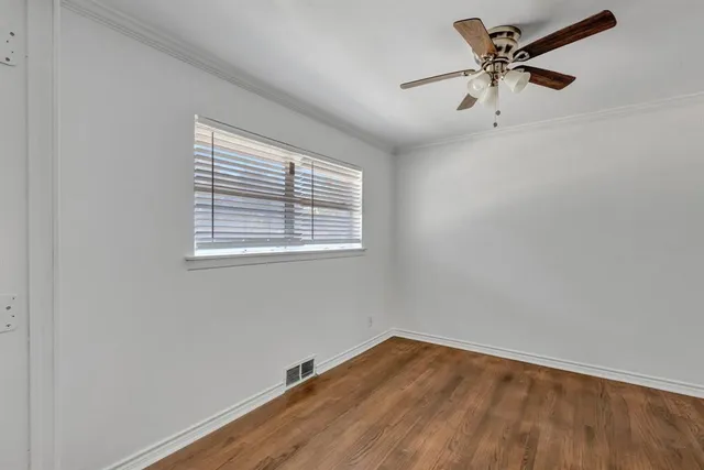 an empty room with a window and a fan