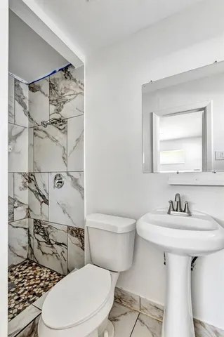 a bathroom with a sink toilet and shower