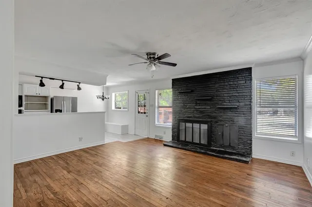 a view of a livingroom with wooden floor and a ceiling fan