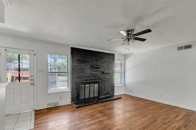 an empty room with windows and fireplace