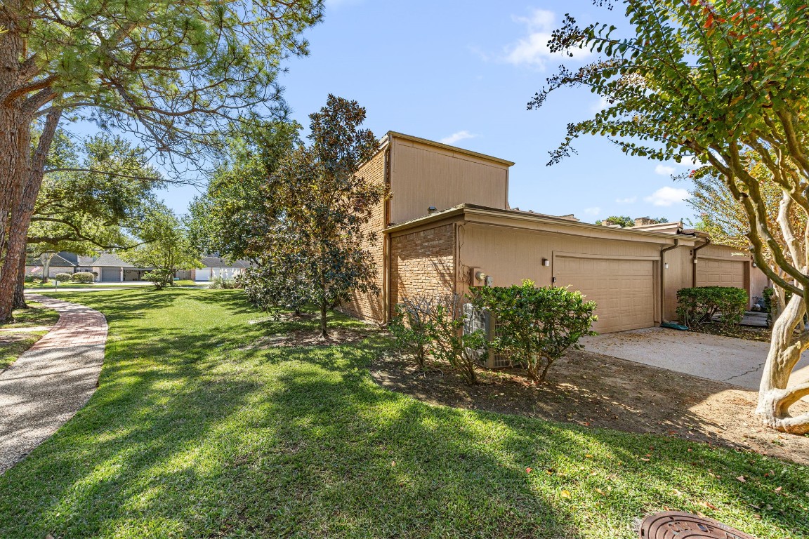15686 Barkers Landing Road Houston, TX 77079 - Photo 30 of 32 Around back leads to the attached 2-car garage w/ mature trees & maintained landscaping.