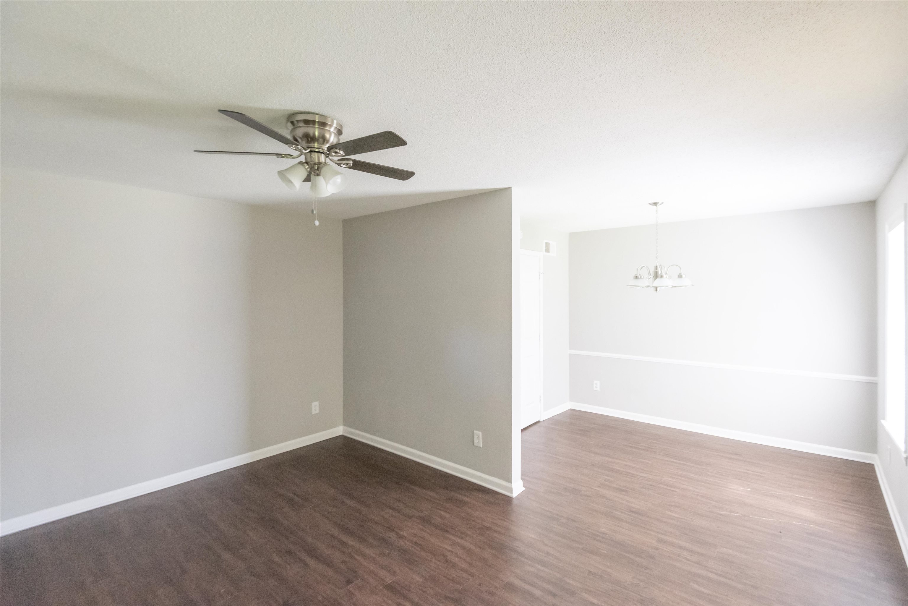 4399 Pepper Tree Road Memphis, TN 38109 - Photo 7 of 14 Wood-finish flooring throughout, neutral paint, ceiling fan, and chandelier lighting