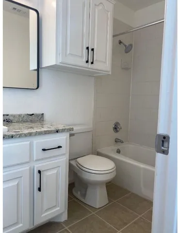 a bathroom with a granite countertop toilet a sink and bathtub