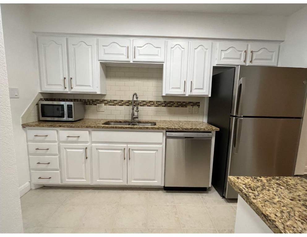 201 East 35th Street, Unit A Austin, TX 78705 - Photo 9 of 25 a kitchen with stainless steel appliances granite countertop a refrigerator sink and cabinets