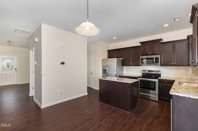 a kitchen with stainless steel appliances wooden floors and wooden cabinets