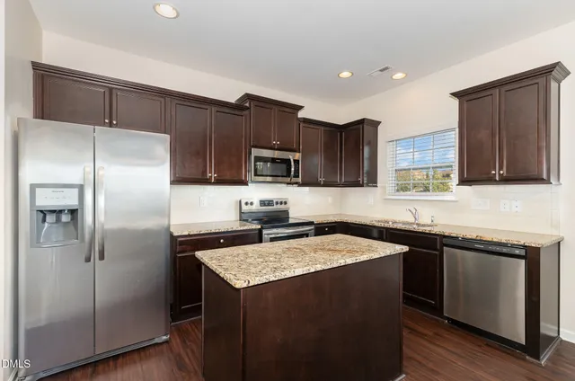 a kitchen with a sink a refrigerator and cabinets